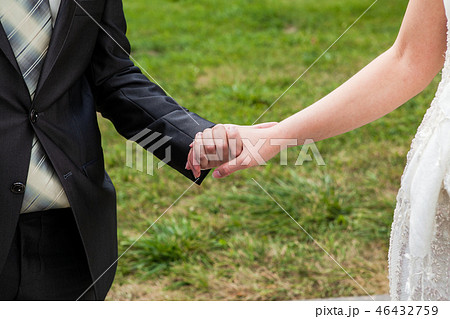 The groom holds the bride by the hand 46432759
