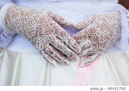 Wedding gloves of lace on hands of bride. 46432760
