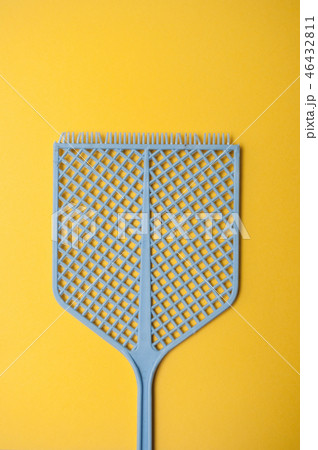 closeup of blue fly swatter on yellow background closeup of blue fly swatter on yellow background 46432811