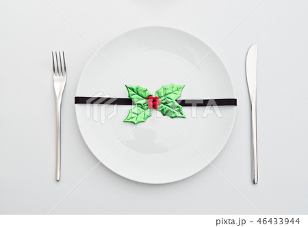 Christmas decoration with holly leaves on plate 46433944