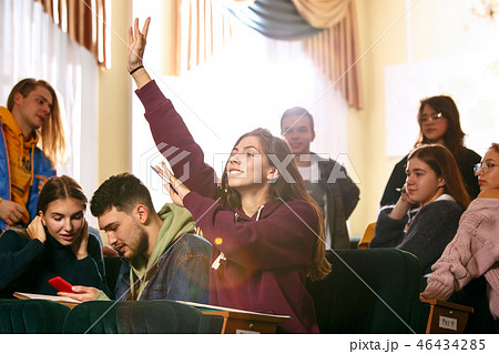 The group of cheerful happy students sitting in a lecture hall before lesson 46434285