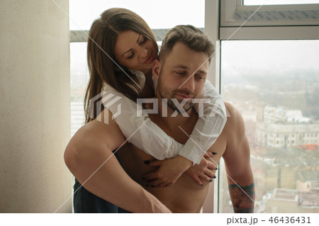 Beautiful romantic couple hugging against window Beautiful romantic couple hugging against window 46436431