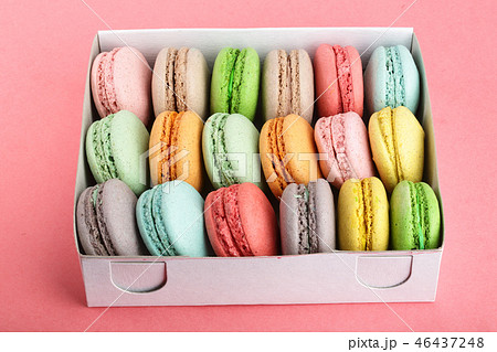 colorful macaroons in box on red white background closeup 46437248