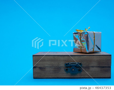 small shiny gift box on wooden chest 46437353