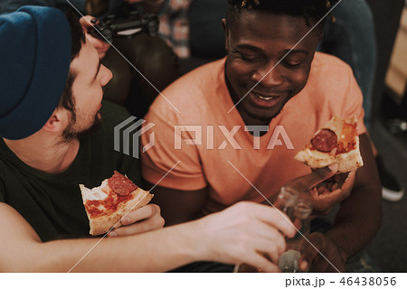 Two male friends enjoying food and drinks at home Two male friends enjoying food and drinks at home 46438056