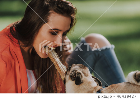 Happy owner is playing with her dog and biting toy bone Happy owner is playing with her dog and biting toy bone 46439427
