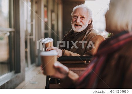 Joyful old man spending time with wife at outdoor cafe 46439999