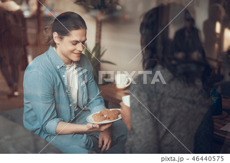 Cheerful man smiling and looking at the plate with cookies 46440575