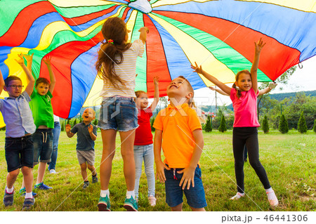 Overjoyed kids bouncing under rainbow canopy textile 46441306