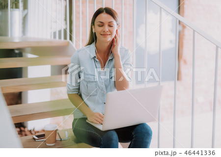 Charming young lady with white laptop listening music Charming young lady with white laptop listening music 46441336