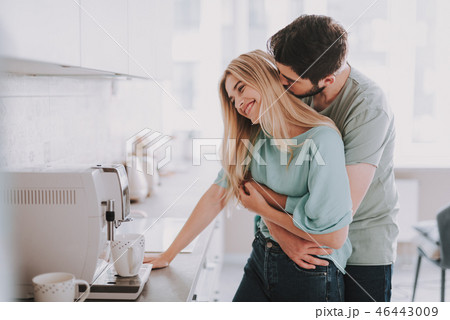 Beautiful cheerful couple relaxing in their kitchen Beautiful cheerful couple relaxing in their kitchen 46443009
