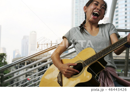 women playing acoustic guitar on walking street. women playing acoustic guitar on walking street. 46443426