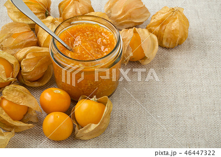 Golden berry jam in glass jar background 46447322