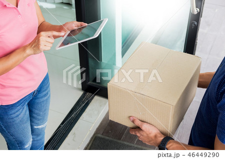 woman courier holding a parcel Shipping Mail appending signature woman courier holding a parcel Shipping Mail appending signature 46449290