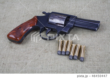 Revolver with ammunition on the canvas background Revolver with ammunition on the canvas background 46450447