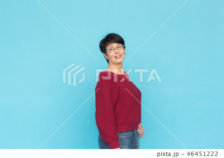 Fashion, people and style concept - Mid-aged woman in crimson sweater on blue background with copy 46451222