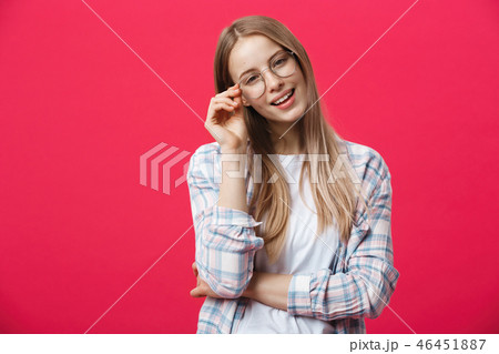 Portrait of a casual woman in glasses looking at camera isolated on a pink background Portrait of a casual woman in glasses looking at camera isolated on a pink background 46451887