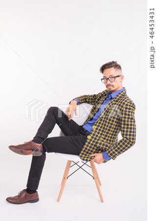 Fashion and people concept - handsome bearded confident man sitting on chair on white background Fashion and people concept - handsome bearded confident man sitting on chair on white background 46453431