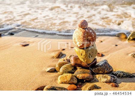 Zen stone pyramid at a beach with surf Zen stone pyramid at a beach with surf 46454534