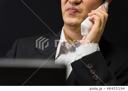 渋い顔で困惑しながら電話しているビジネスマン 46455194