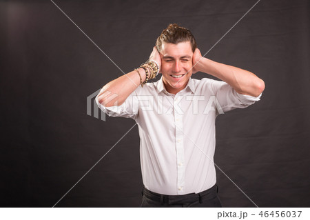Handsome man covering his ears with both hands and looking at the camera on brown background. 46456037
