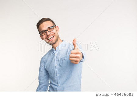 Gesture of approval and correctness concept - Happy handsome man showing thumb up on white 46456083