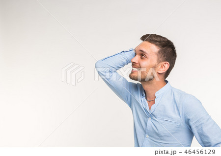 Expressions and people concept - Portrait of a young bearded man holding hands at his head isolated 46456129