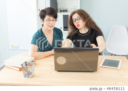 Business, technology and people concept - two women discuss a project watching in laptop 46458111