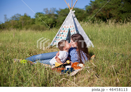 mother and young son eating at a picnic outdoors tent mother and young son eating at a picnic outdoors tent 46458113