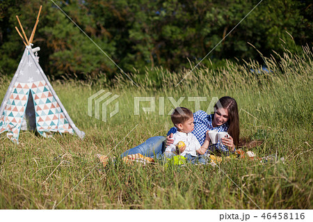mother and young son eating at a picnic outdoors tent 46458116