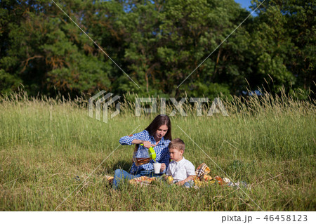 mother and young son eating at a picnic outdoors tent mother and young son eating at a picnic outdoors tent 46458123
