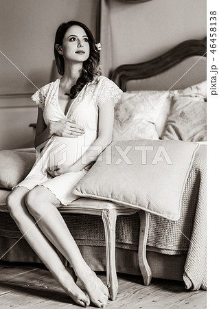 Young pregnant woman in white dress sitting 46458138