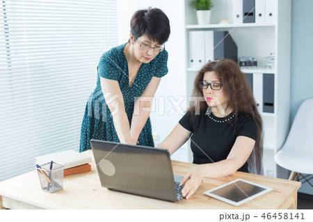 Office, business people and graphic designer concept - Women sitting and discussing ideas at the Office, business people and graphic designer concept - Women sitting and discussing ideas at the 46458141