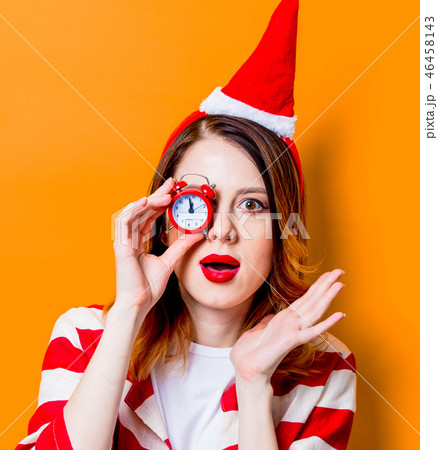 woman in Santa Claus hat with little alarm clock woman in Santa Claus hat with little alarm clock 46458143