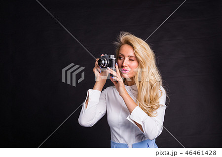 Photographing, fashion and people concept - young blonde woman making a photo from something on 46461428