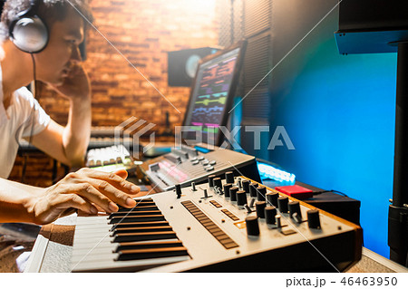 asian male composer making music in sound studio 46463950
