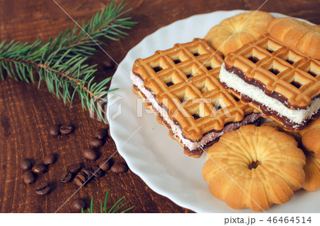 Plate with fresh cookies on dark wooden board.  46464514
