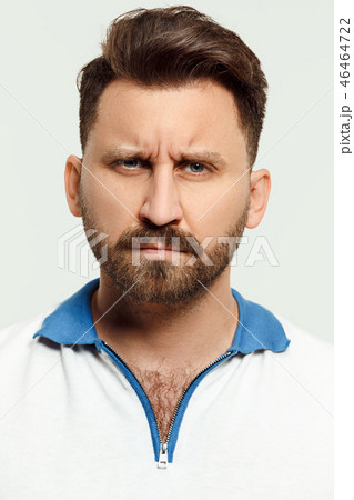 The serious man standing and looking at camera against white background. 46464722