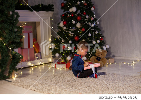 boy open up gifts from Christmas New Year holiday house 46465856