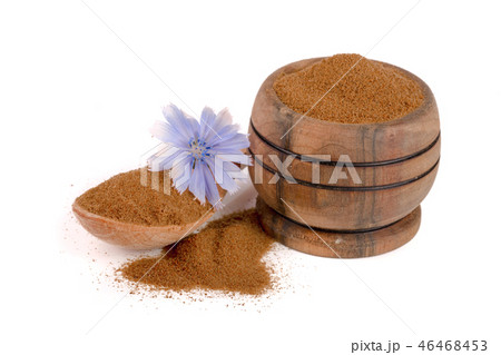 chicory powder in a bowl and spoon with a flower isolated on white background 46468453
