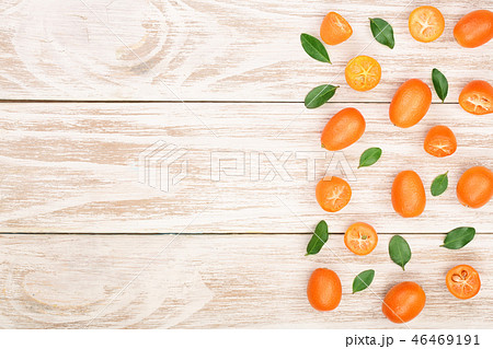 Cumquat or kumquat with leaf on white wooden background with copy space for your text. Top view 46469191
