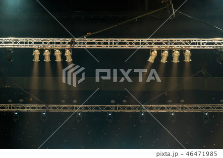 Luminous rays from concert lighting against a dark background over the projector screen, musical instrument concept 46471985