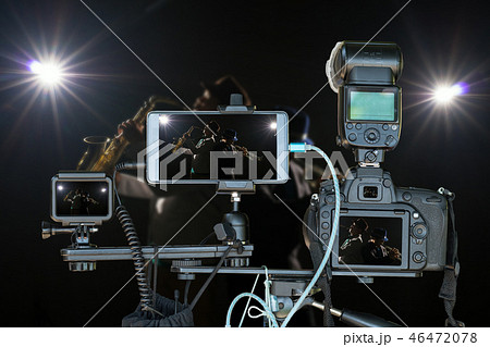 Professional set of camera with smart mobile phone and action camera on tripod over Musician Duo band playing the Trumpet with spot light and lens flare on the stage,Live Streaming for musical concept 46472078