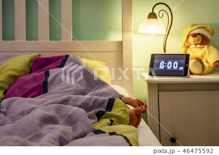 Little girl sleeping in bed - Alarm clock at 6 am in the morning. Little girl sleeping in bed - Alarm clock at 6 am in the morning. 46475592