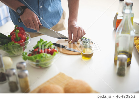 Man chopping garlic with knife on cutting board 46480853