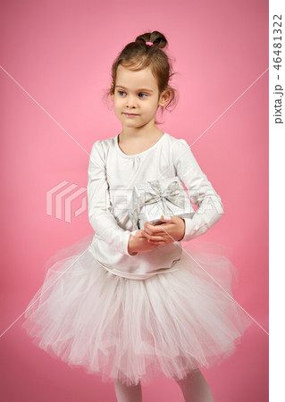 Cute little girl in tulle skirt is holding a gift on a pink background Cute little girl in tulle skirt is holding a gift on a pink background 46481322