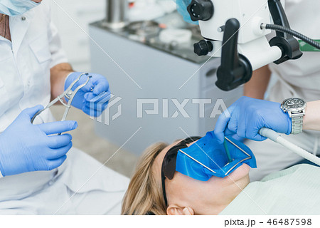 Doctor used microscope. Dentist is treating patient in modern dental office. Operation is carried 46487598