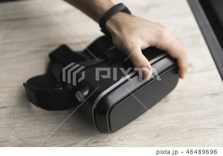 VR virtual reality glasses on a table with a man hand. VR virtual reality glasses on a table with a man hand. 46489696