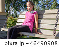 Smiling girl sitting on swing bench in the park 46490908