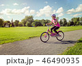 Girl in a helmet riding a bicycle in summer park 46490935